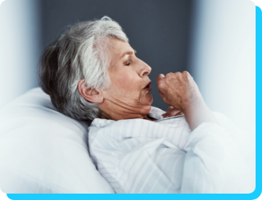 Image of older woman coughing while lying in bed