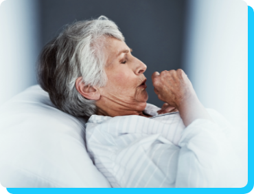 Image of older woman coughing while lying in bed Image of older woman coughing while lying in bed
