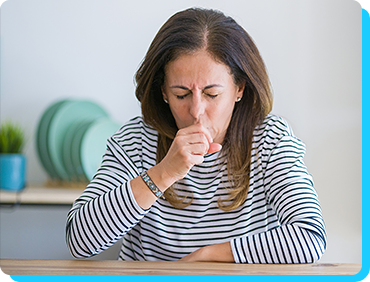 Image of woman coughing while sitting at table Image of woman coughing while sitting at table